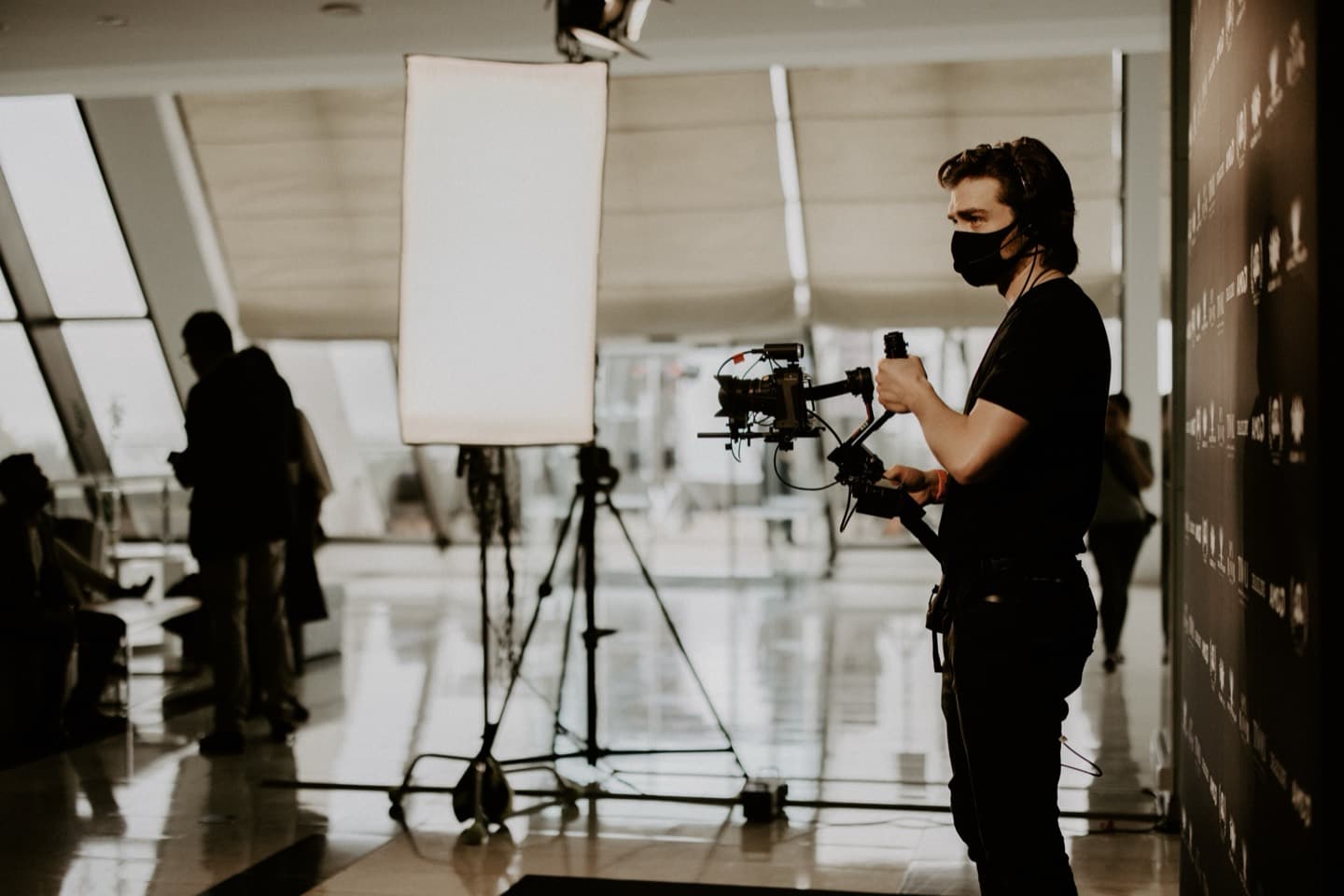 A gimbal operator working the sponsor board, the wall of AMD marks running out of frame behind him