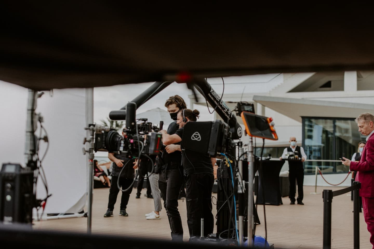 Crew moving through the venue with camera and support between set-ups