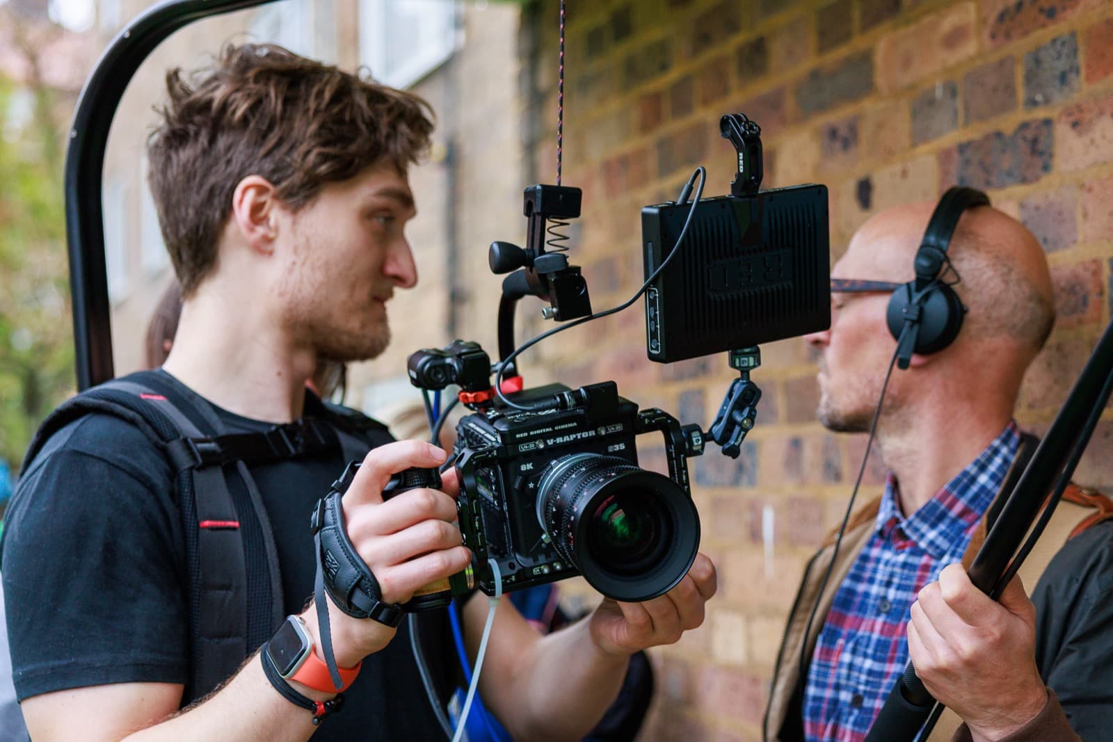 Two of the crew on location, one monitoring sound on headphones