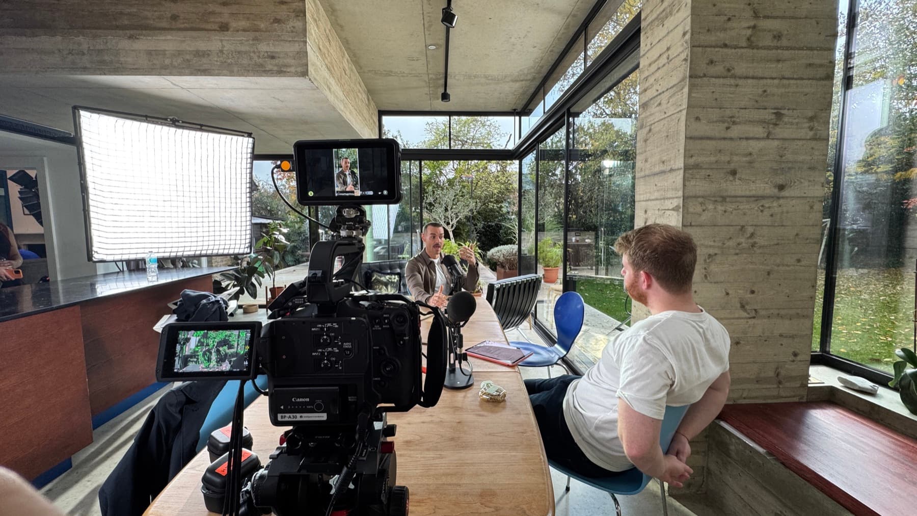 Shooting an interview across a table, the camera and its monitor in the foreground and the frame visible on it