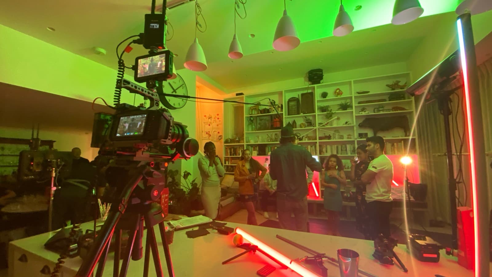 A camera set up in a workshop lit green and red, the shot framed up on the monitor