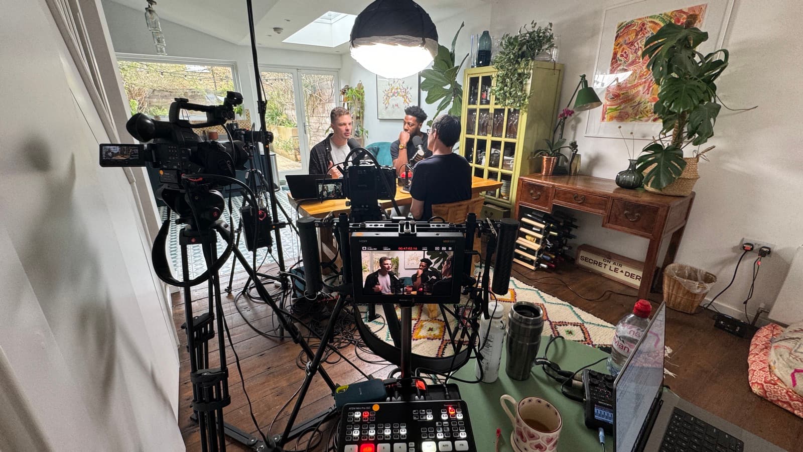 A two-camera podcast set-up run through a vision mixer, both feeds live on the monitor