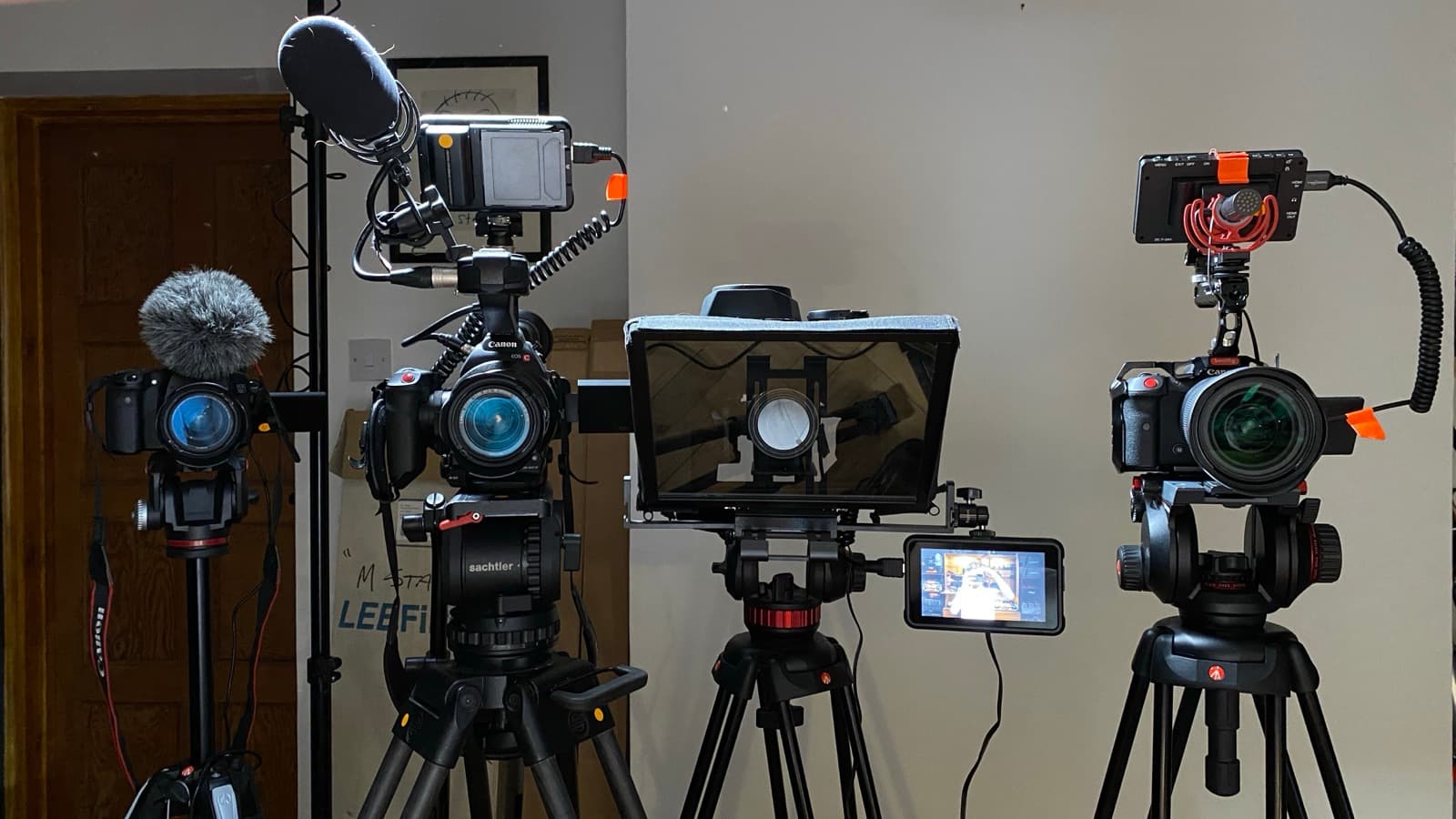 Three cameras and a teleprompter set up for an interview, shotgun mic and monitor rigged alongside