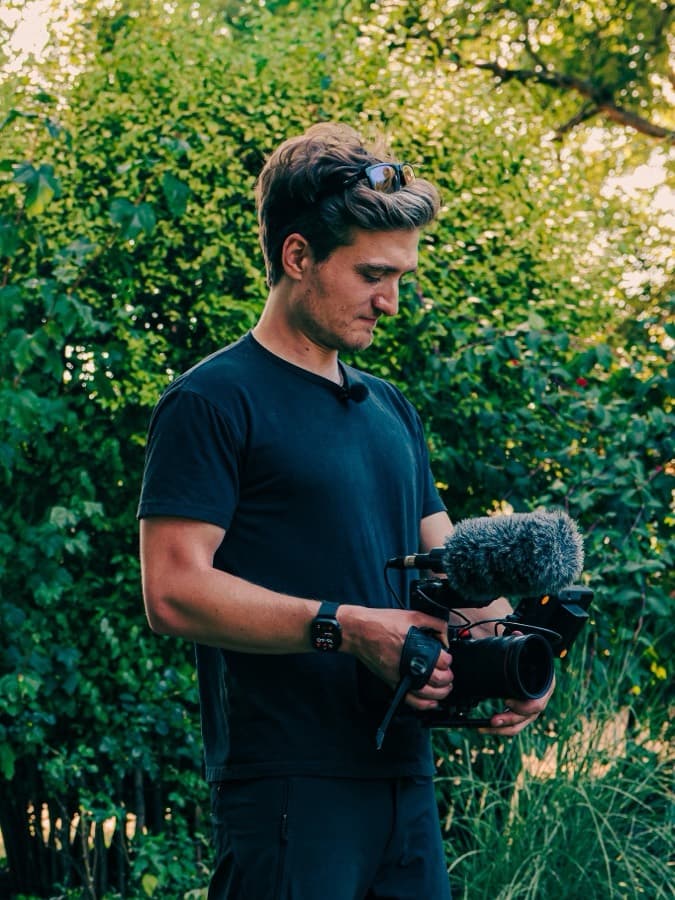 Jack Hobbs operating a rigged camera on location, late light behind him
