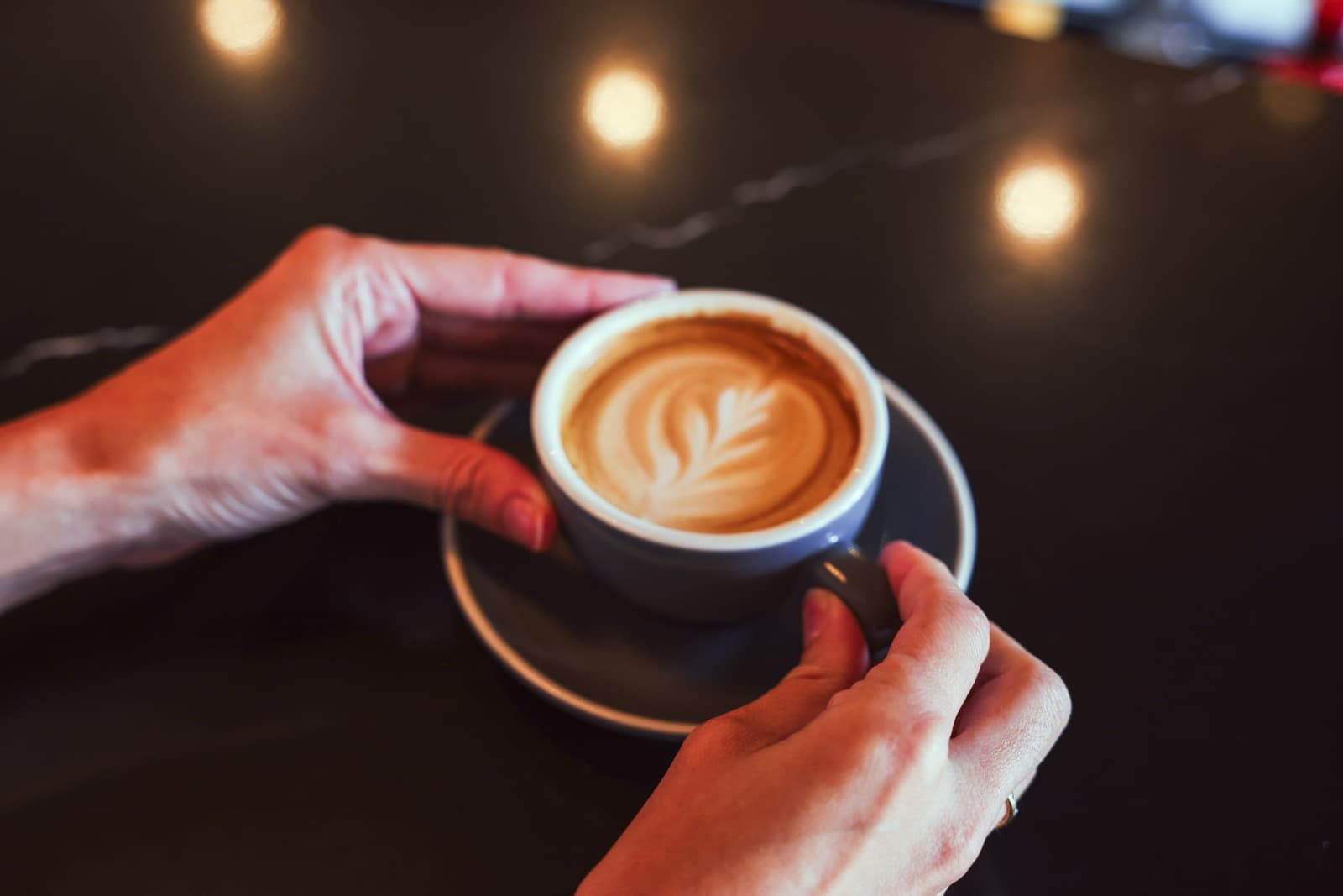 A flat white set down on the bar, latte art intact