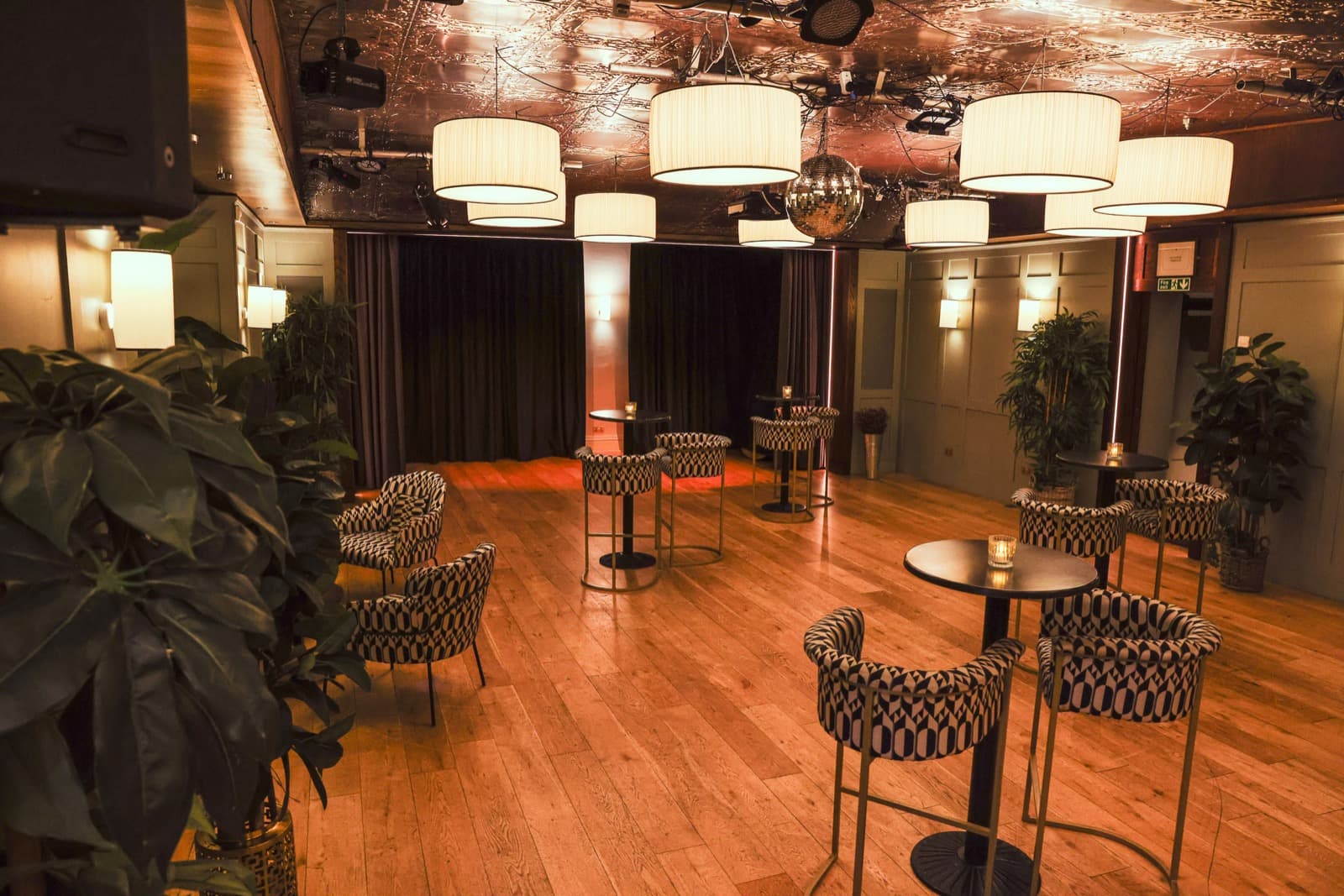 The club room before service, lamps lit and tables set