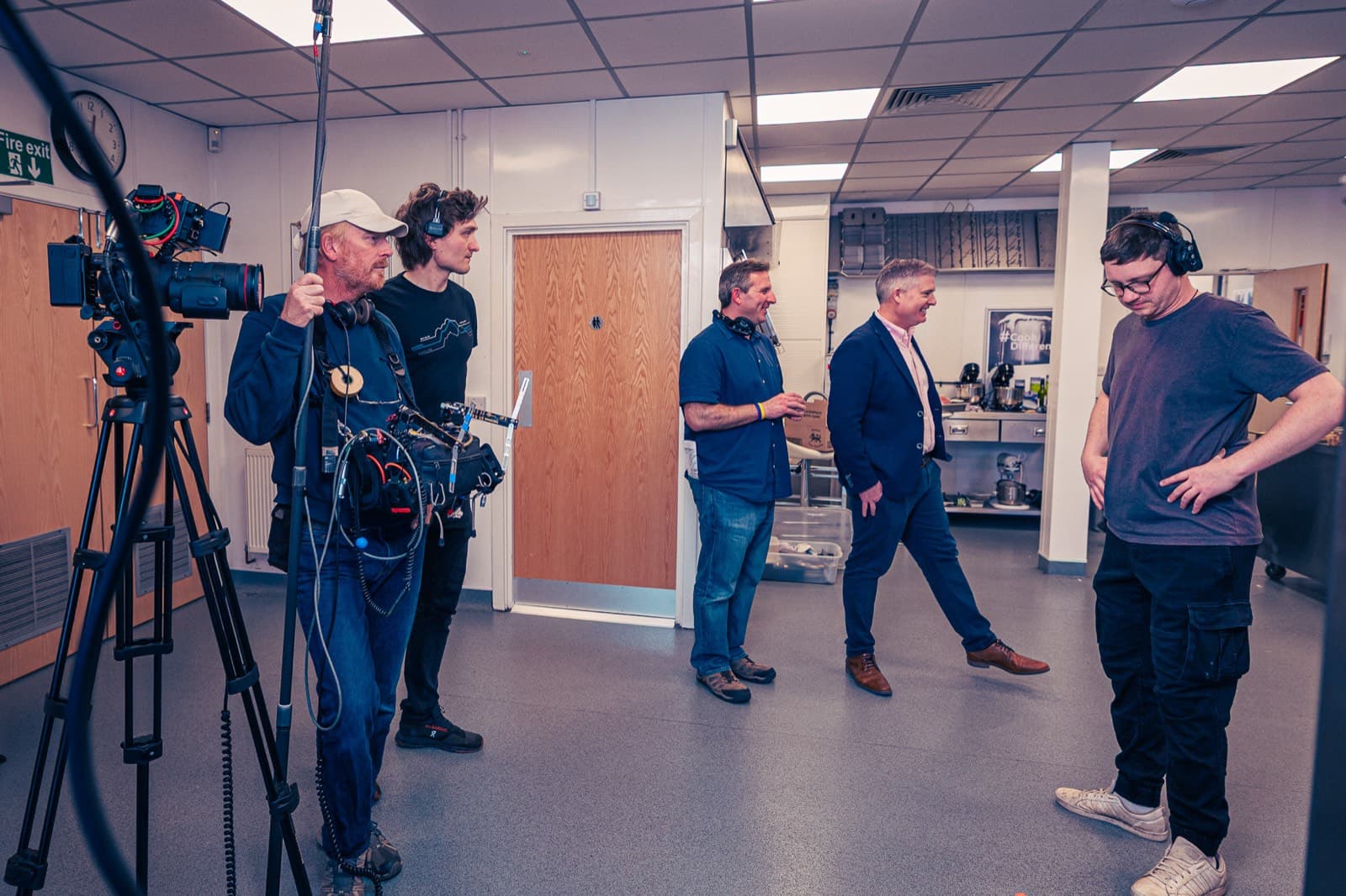 Between takes — sound and camera holding while the room resets around them