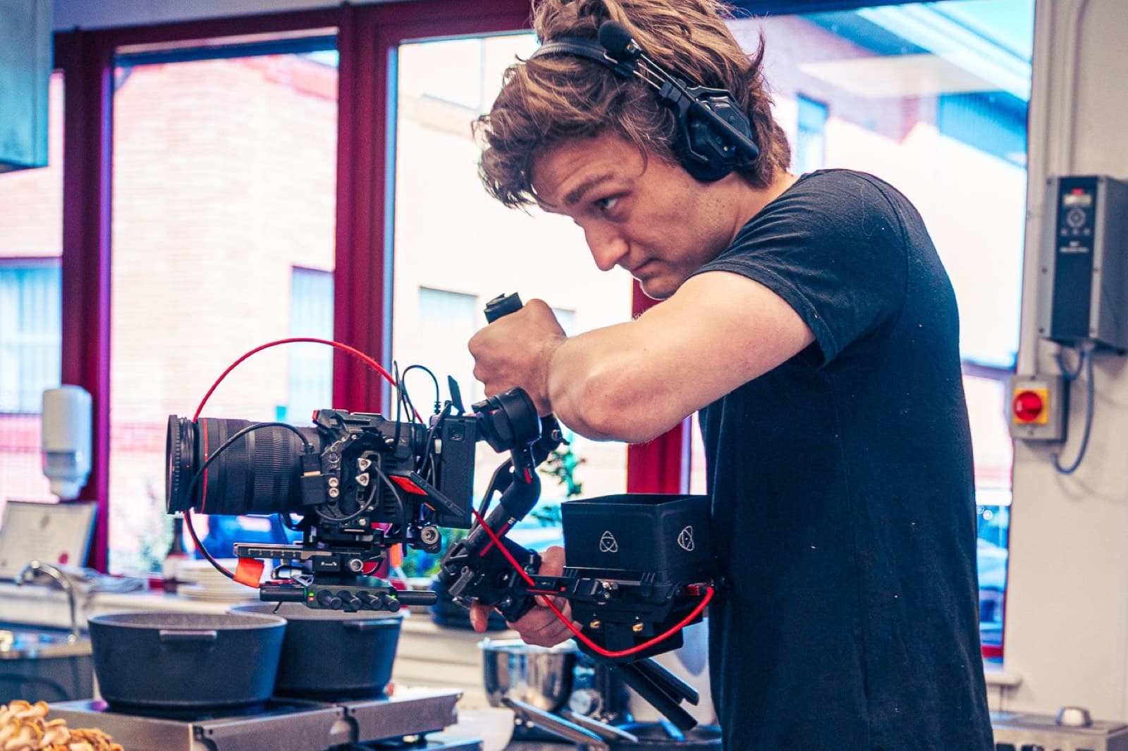 An operator working a gimbal-mounted camera across the pans on the range