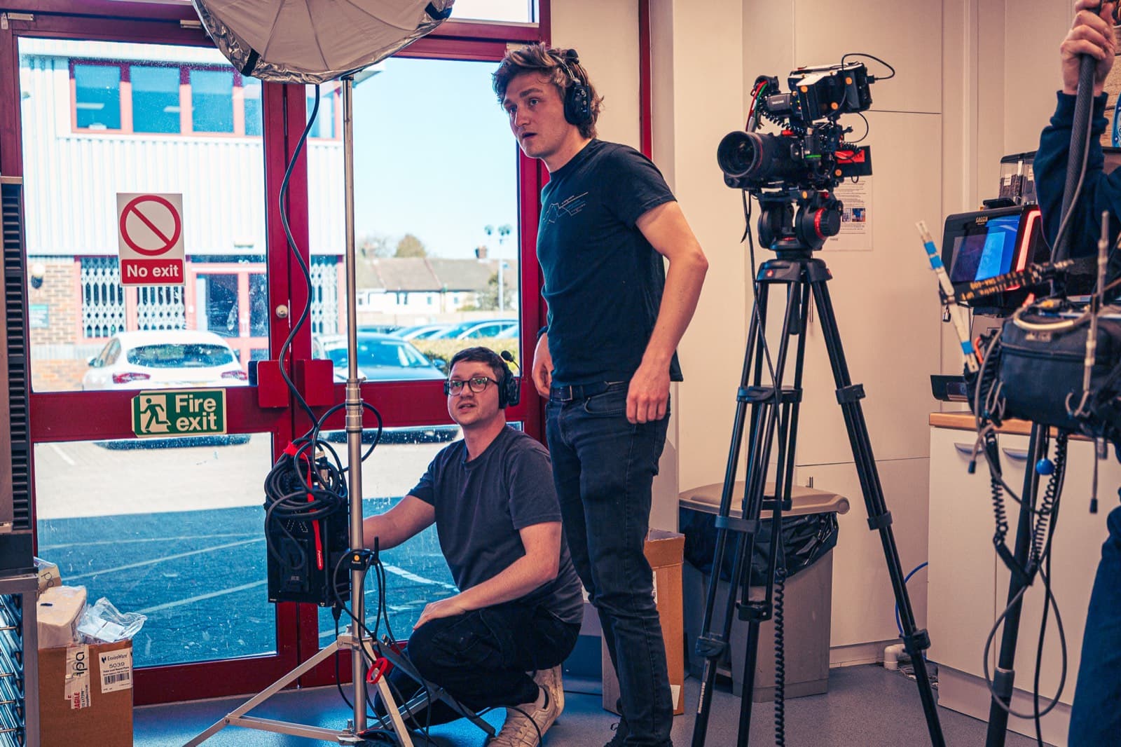 Two of the crew building a light and camera position by the kitchen door